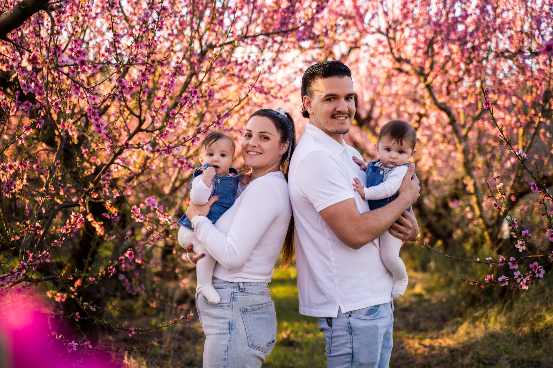 Famille avec deux enfants sous les cerisiers en fleurs