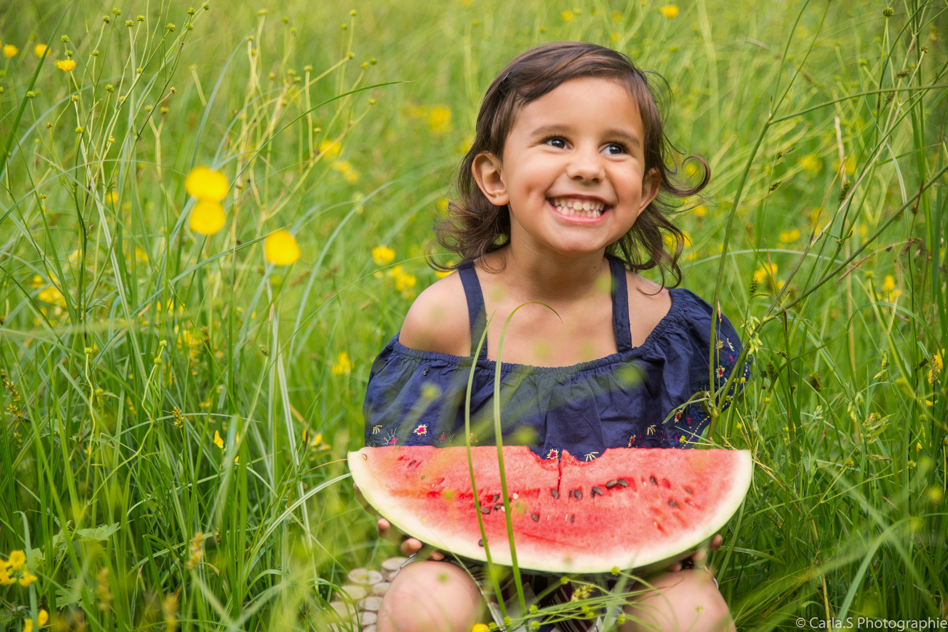 Enfant dans champs avec tranche de pastèque