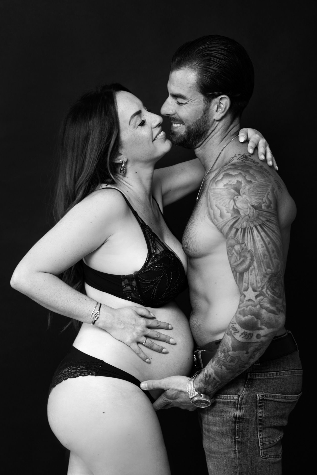 Grossesse couple studio fond noir photo en noir et blanc