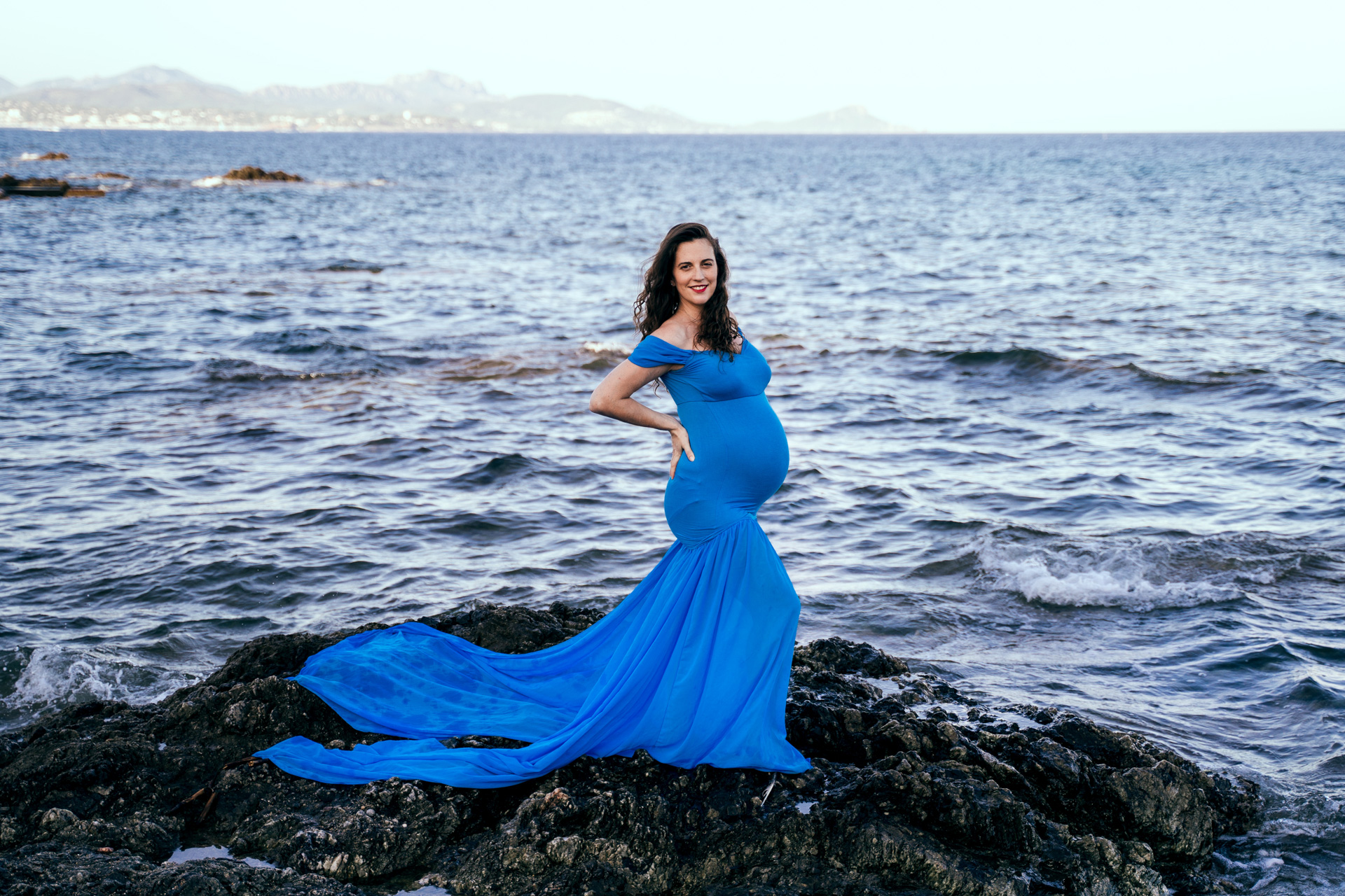 Femme enceinte robe bleue au bord de la mer
