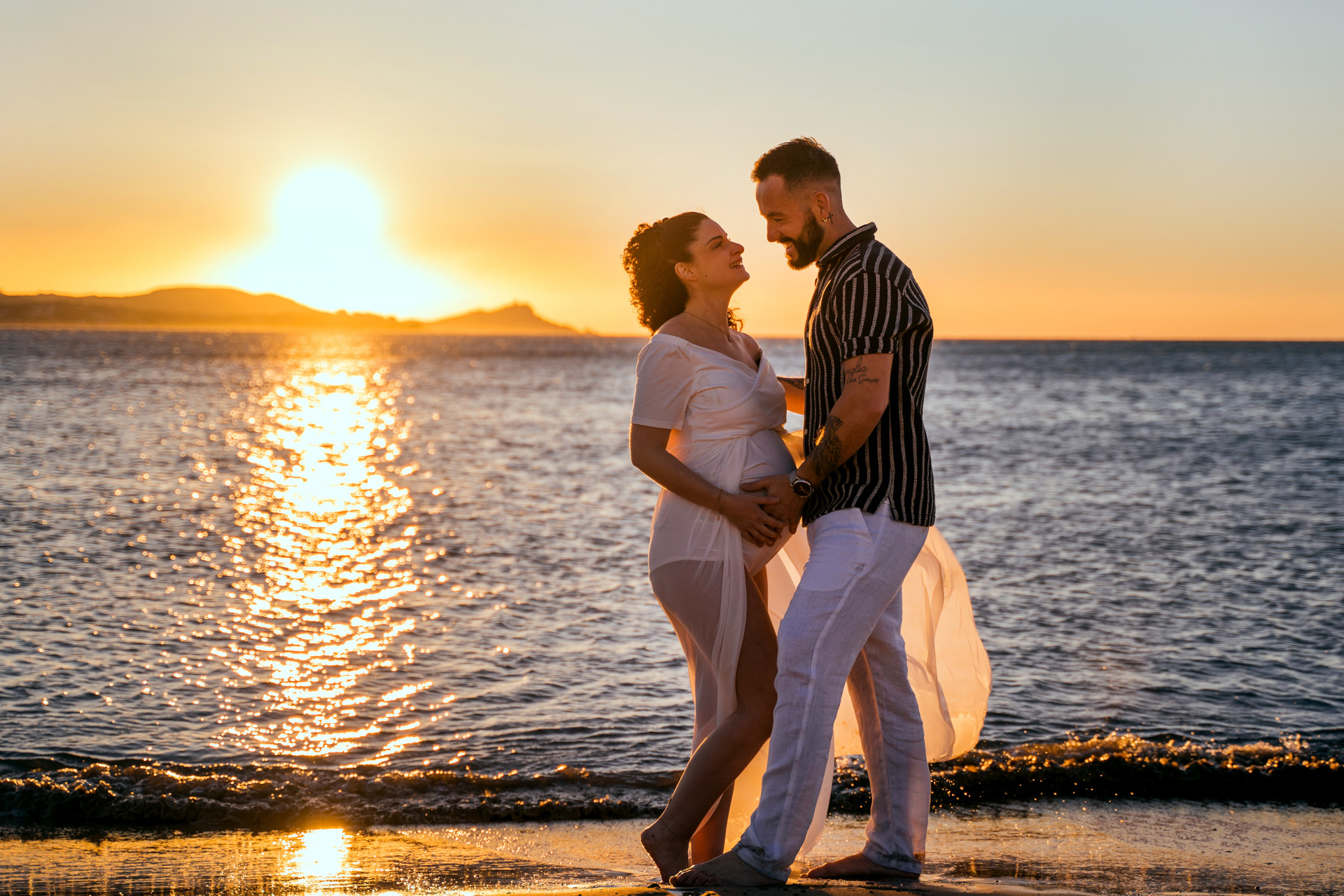 Grossesse couple coucher de soleil plage