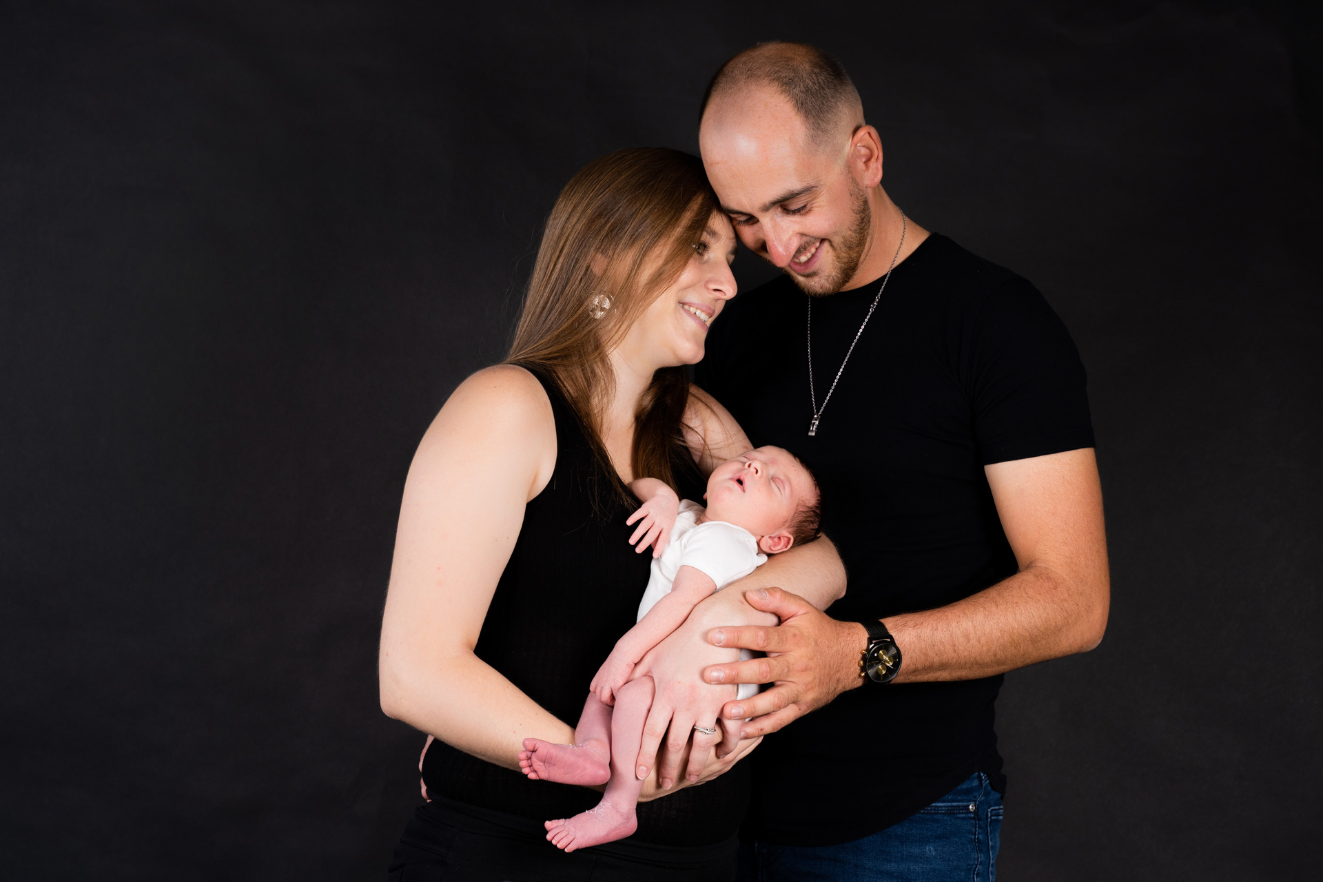 Couple avec nouveau-né studio fond noir